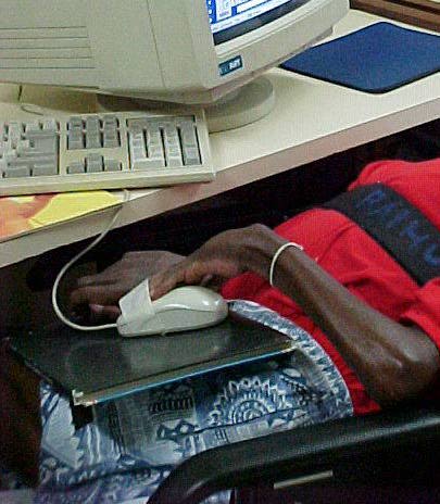 Foto de mouse reposicionado no colo do aluno e preso na m�o com fita adesiva