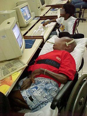 Foto de aluno comandando o computador por meio de sopros no microfone